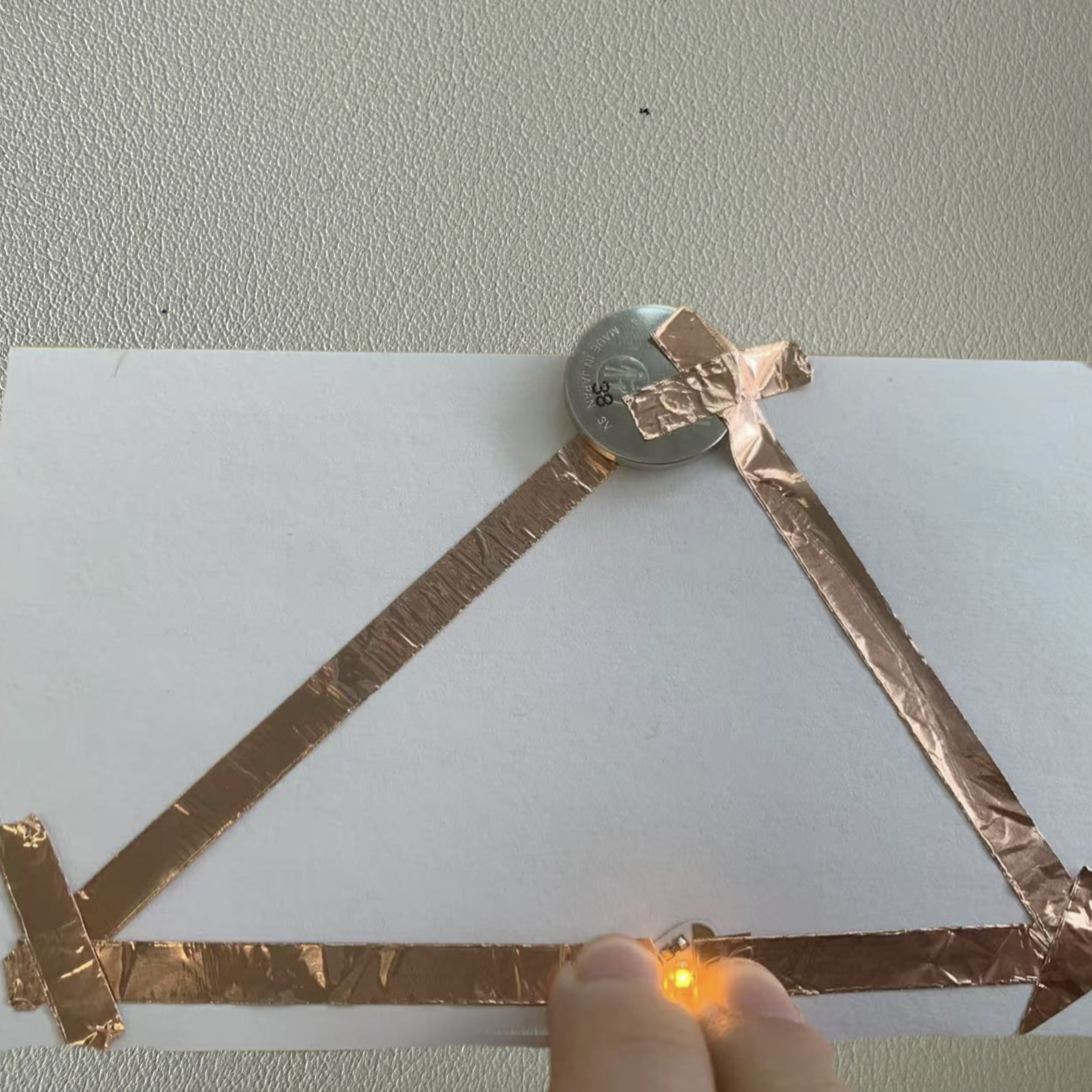 The triangular circuit was completed with all components securely in place, showcasing a creative design while functioning properly.