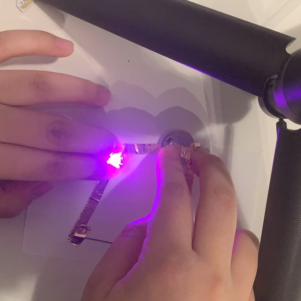 I pressed the components together, and the light emitted a purple glow, confirming that the pencil lead effectively conducts electricity.